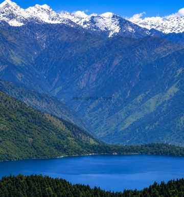 Crystal-clear Rara Lake with lush forests and Himalayan peaks in Rara National Park, Nepal.